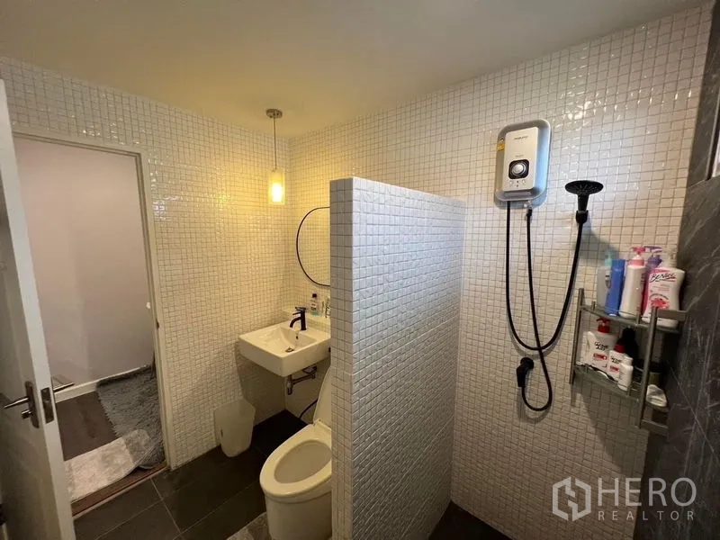 Detached House for sale in Bang Kruai, Nonthaburi - Bathroom with white mosaic walls, walk‑in shower with water heater, vanity and toilet.