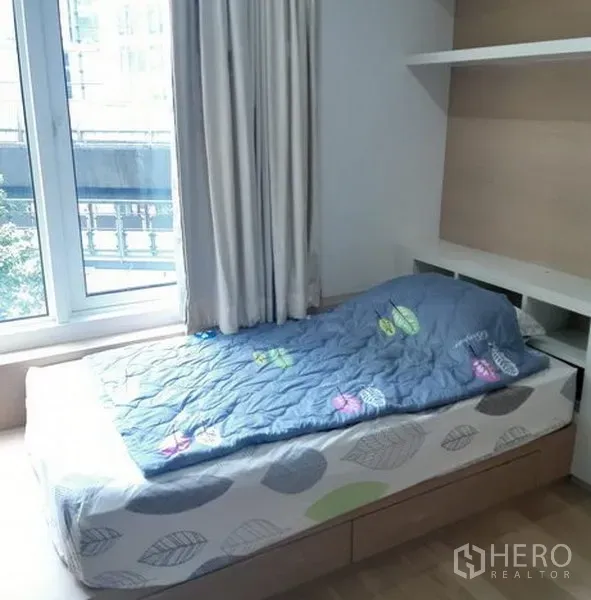 公寓 出租在Khlong Toei, Bangkok - 舒适卧室，单人床与大窗户，可见城市景观。