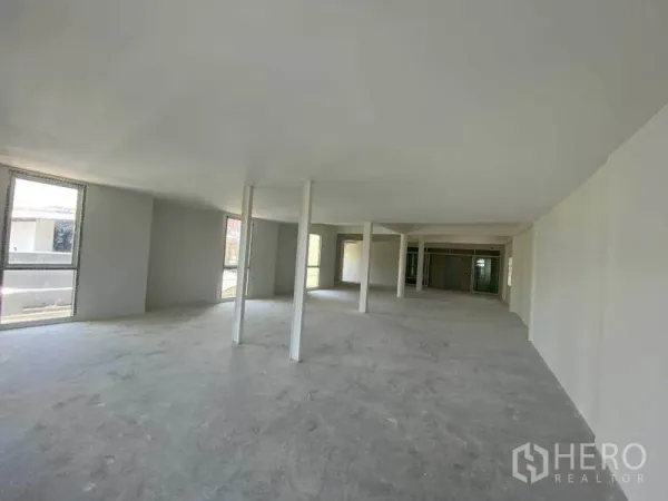 Retail Space for rent in Khlong Toei, Bangkok - Bright open space with perimeter windows and concrete flooring, ideal for displays.