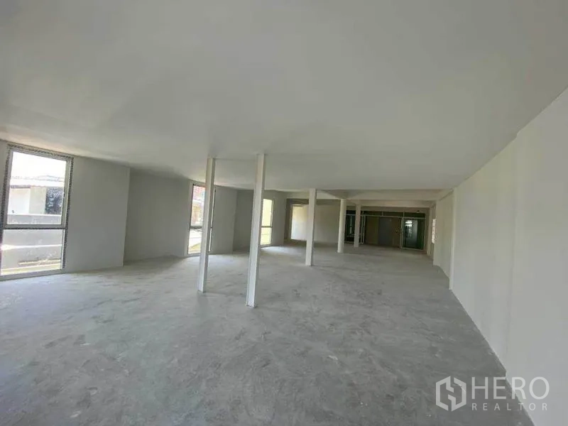 Retail Space for rent in Khlong Toei, Bangkok - Bright open space with perimeter windows and concrete flooring, ideal for displays.