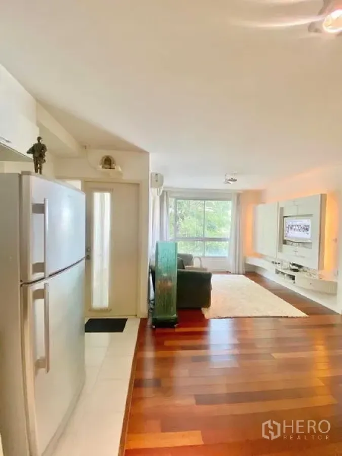 Condominium for rent in Watthana, Bangkok - Entry corridor opening to a bright living room with media unit and wide window.