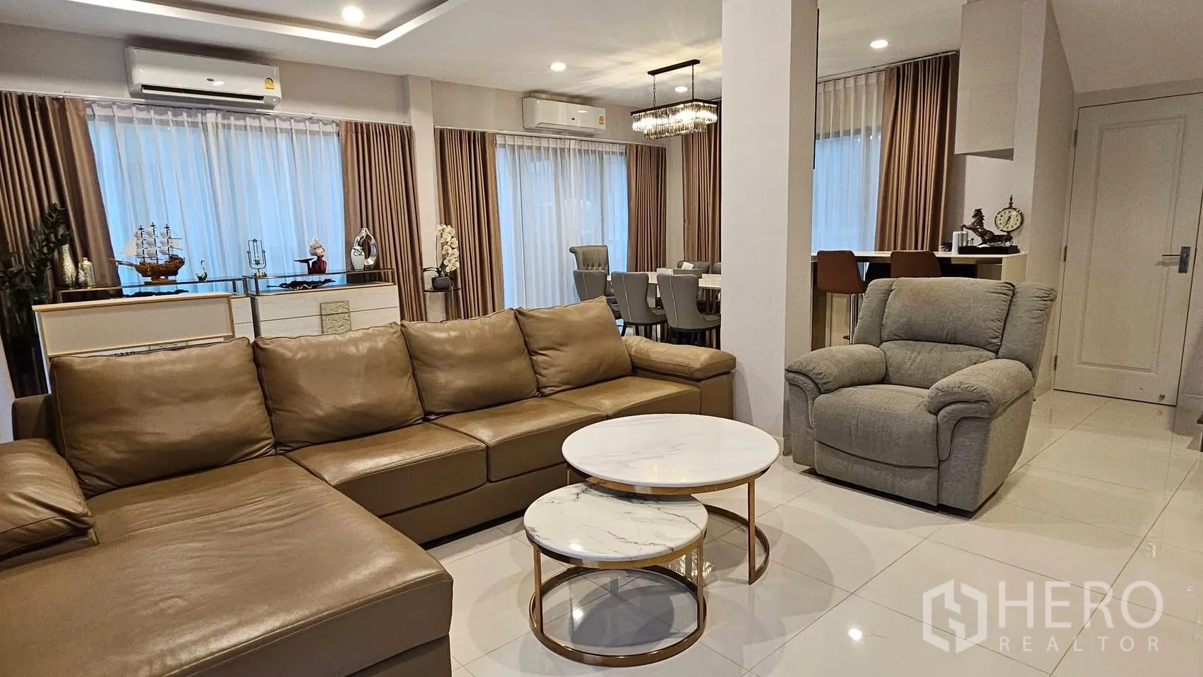 Detached House for rent in Saphan Sung, Bangkok - Open-plan lounge leading to dining zone with large windows and curtains.