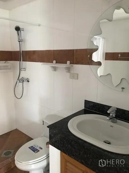 公寓 出租在Watthana, Bangkok - 白色浴室，配手持花洒、坐便器与花岗岩台面洗手台。