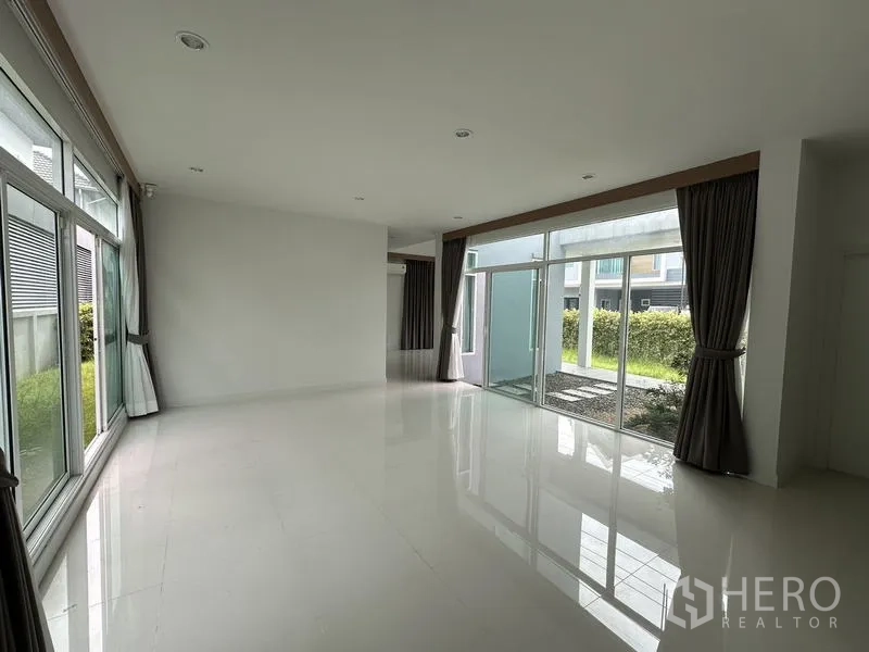 Detached House for sale in Lam Luk Ka, Pathum Thani - Spacious family room with full-height sliding glass doors opening to the garden.