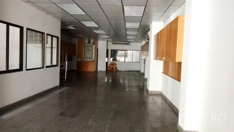 Office Space for rent in Sathon, Bangkok - Long office hall with granite floors, ceiling panels, and built-in storage cabinets.