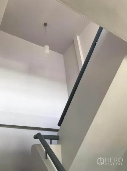 Townhouse for rent in Suan Luang, Bangkok - Airy stairwell featuring a minimalist handrail and pendant light.
