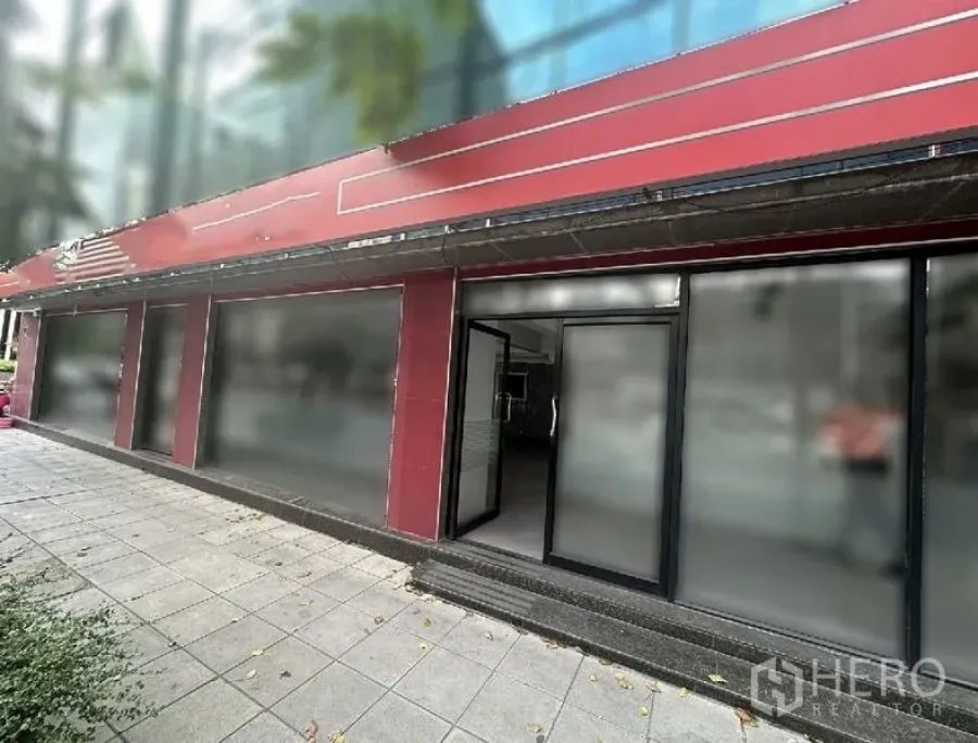 Retail Space for rent in Bang Rak, Bangkok - Street-level storefront with red facade, black-framed glass entrance and wide pavement.