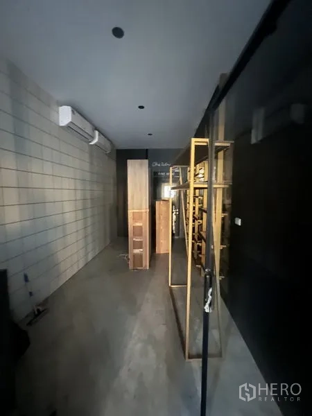 Retail Space for rent in Watthana, Bangkok - Narrow shop corridor with built-in metal shelving and wall-mounted air-conditioning.