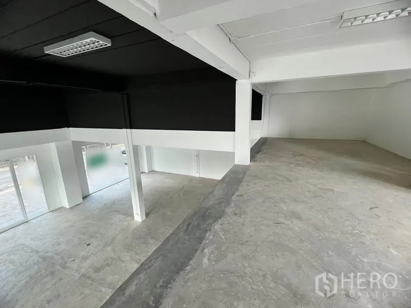 Retail Space for rent in Huai Khwang, Bangkok - Mezzanine view over open-plan retail area with concrete floor and glass walls.