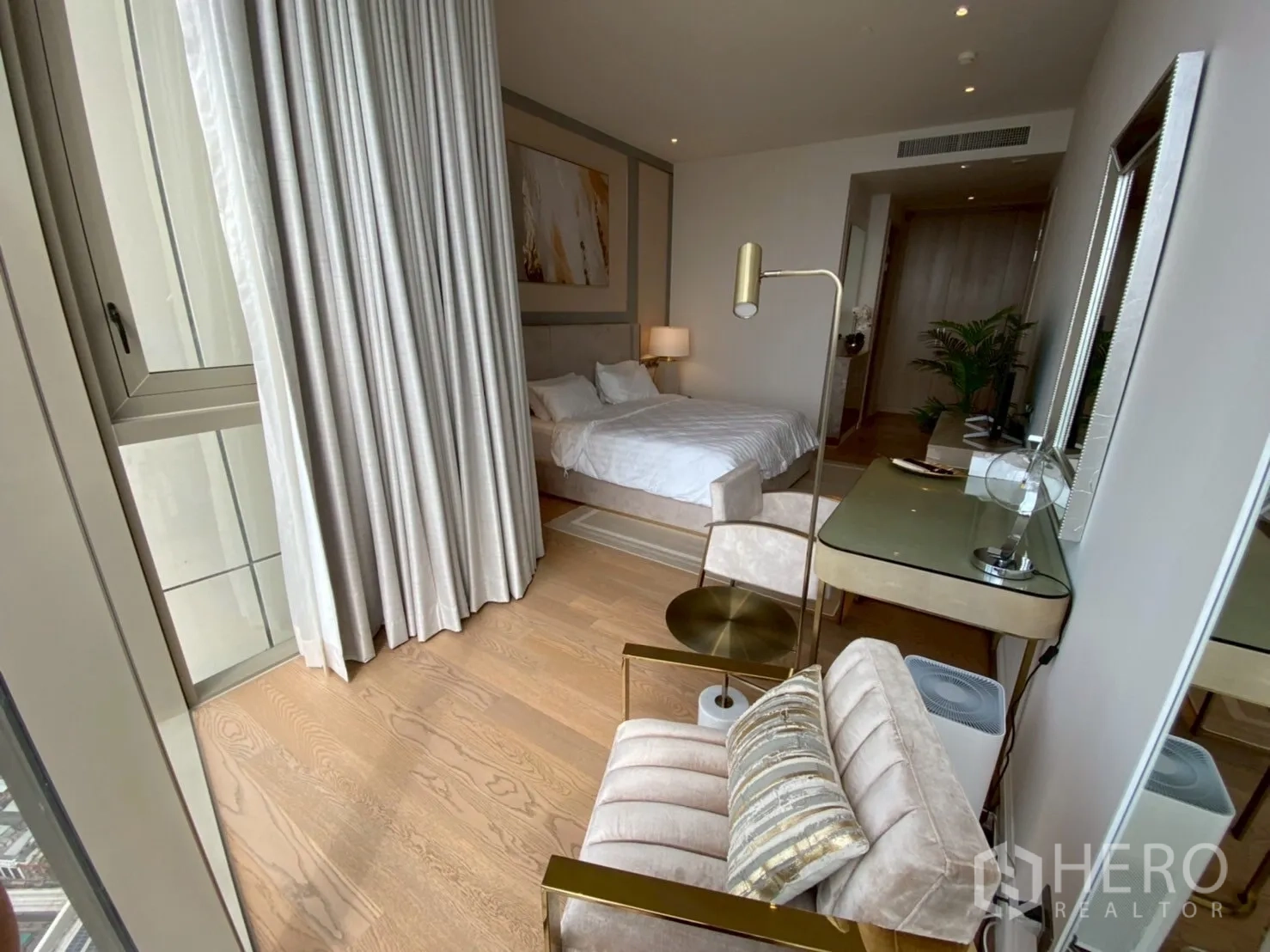 公寓 出租在Khlong San, Bangkok - 卧室设梳妆桌、落地窗与长帘，木地板温馨。