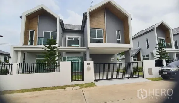 บ้าน ขายในLam Luk Ka, Pathum Thani - บ้านเดี่ยวสไตล์โมเดิร์น หลังคาจั่วคู่ ผนังสีเทา แต่งไม้ พร้อมประตูรั้วและที่จอดรถ ลำลูกกา