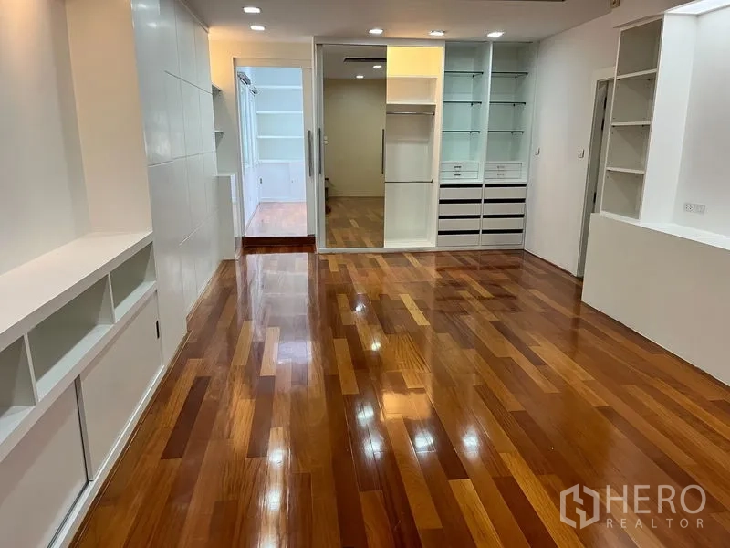 公寓 出租在Khlong Toei, Bangkok - 大房间带内置收纳与展示柜，木地板光洁。