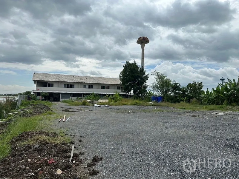 工厂 出租在Lam Luk Ka, Pathum Thani - 碎石场地与配套建筑，远景可见水塔。