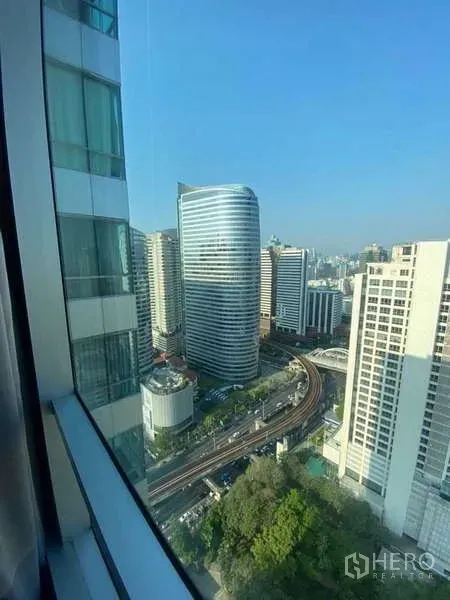 คอนโด ขายในSathon, Bangkok - วิวเมืองกรุงเทพฯ ชั้นสูงจากหน้าต่าง เห็นรางรถไฟฟ้า BTS เซนต์หลุยส์โค้งด้านล่าง.