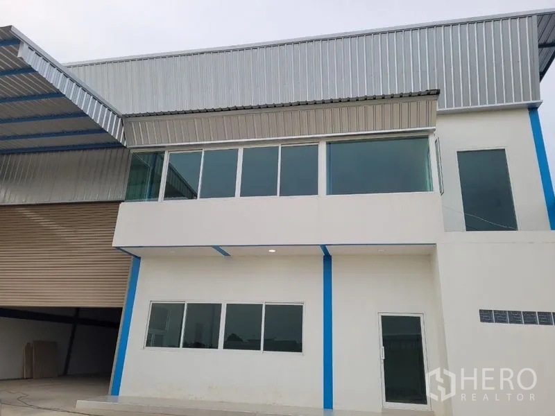 Factory for rent or sale in Khlong Luang, Pathum Thani - Modern factory exterior with glass-fronted office and metal roof in Khlong Luang.