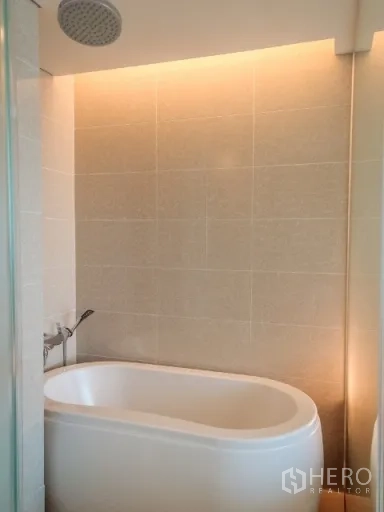 คอนโด ให้เช่าในWatthana, Bangkok - ห้องน้ำสไตล์สปาพร้อมอ่างอาบน้ำลึกและฝักบัวเรนชาวเวอร์ แสงไฟหลืบโทนอุ่น