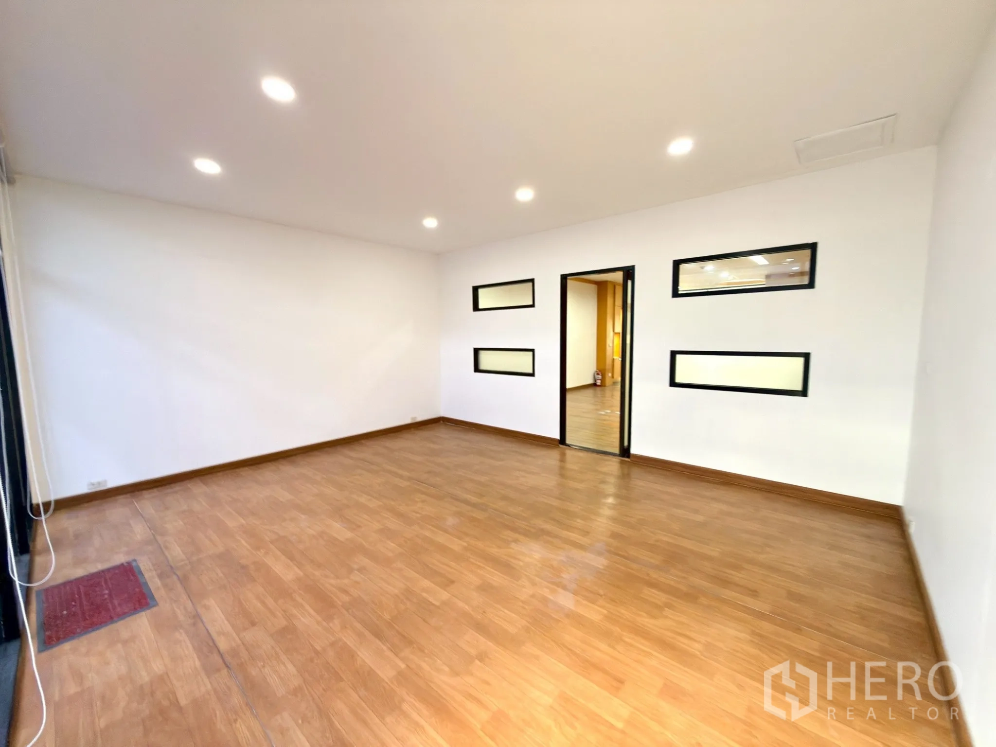 ออฟฟิศ for rent in Watthana, Bangkok - ห้องรองสว่าง พื้นไม้ และช่องหน้าต่างแนวนอนภายในผนัง.