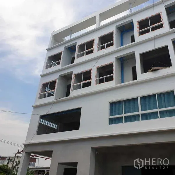 Office Space for rent or sale - Multi-storey white office building facade with open window bays and exposed piping.