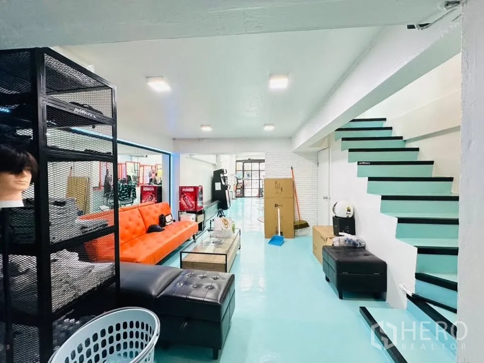 อาคารพาณิชย์ for sale in Watthana, Bangkok - ชั้นล่างโล่ง มองเห็นประตูกระจกด้านหน้าและบันไดสีเทอร์ควอยซ์