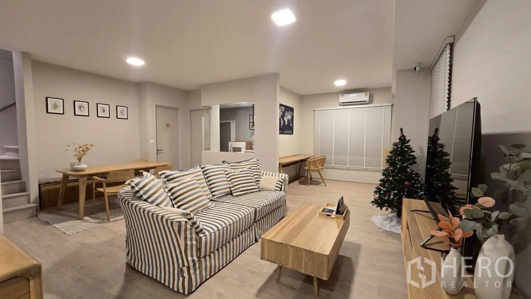 半独立式住宅 for rent in Prawet, Bangkok - 开放式客餐厅，条纹沙发、电视与木质家具