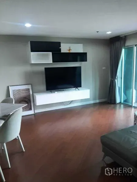 คอนโด ให้เช่าหรือขายในHuai Khwang, Bangkok - ห้องนั่งเล่นสว่างพร้อมทีวีติดผนัง ชั้นลอย และประตูกระจกสู่ระเบียง