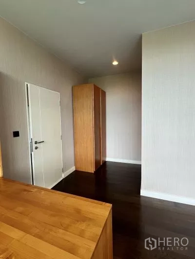 Detached House for rent in Bang Kapi, Bangkok - Upper hallway with dark wood floors, light walls and a freestanding wooden wardrobe.