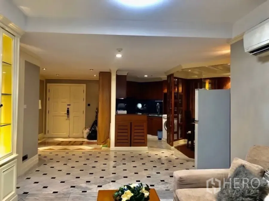 Condominium for rent in Watthana, Bangkok - Open-plan living area with marble-look floor, built-in cabinetry and a view toward the kitchen
