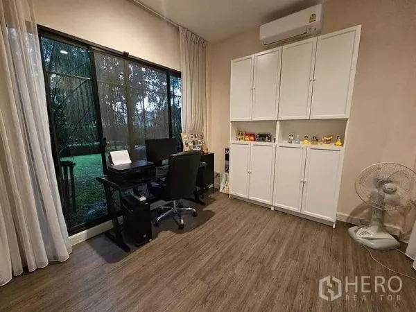 Detached House for sale in Bang Kruai, Nonthaburi - Ground-floor study with large window to a green garden, white built-in cabinets and a work desk.