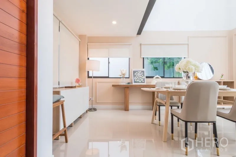 Townhouse for rent or sale in Suan Luang, Bangkok - Entry perspective into the dining room with soft lighting and windows.