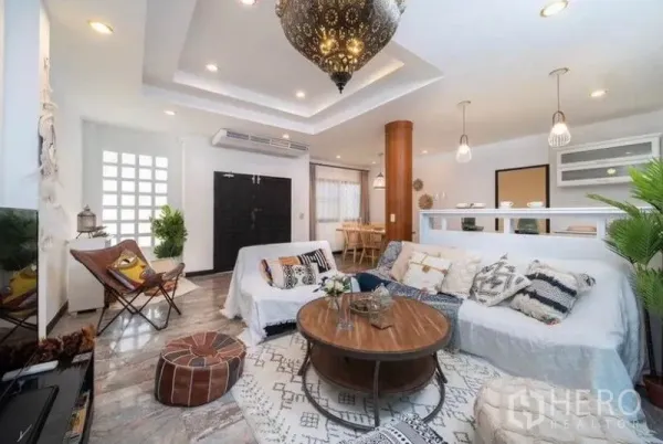 独立式住宅 出租在Ratchathewi, Bangkok - 明亮客厅，层次吊顶、摩洛哥风吊灯与舒适沙发。