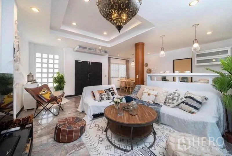 独立式住宅 出租在Ratchathewi, Bangkok - 明亮客厅，层次吊顶、摩洛哥风吊灯与舒适沙发。
