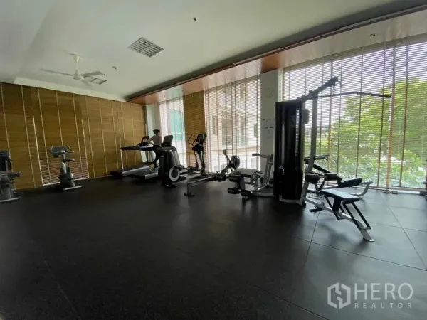 公寓 出租在Yan Nawa, Bangkok - 公寓健身房，配備跑步機、健身車與重訓器材，臨落地窗。