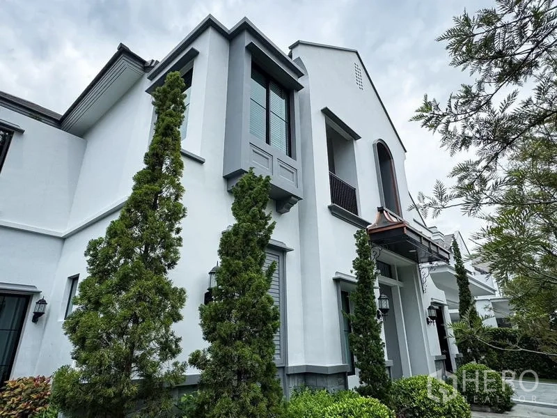 Detached House for rent or sale - Side exterior facade with bay windows, small balconies, and tall evergreens.