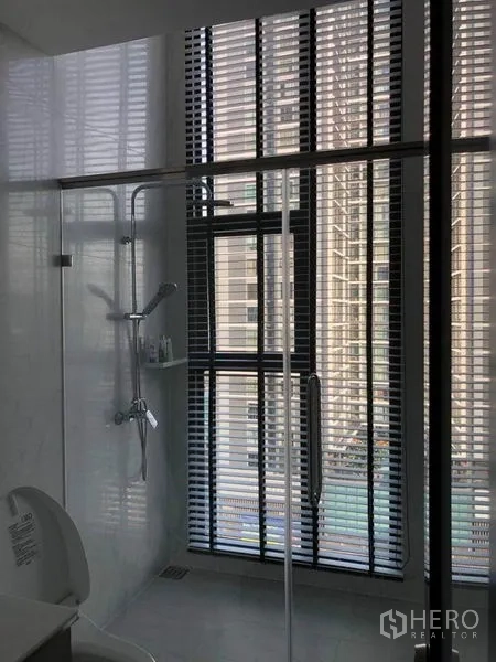 公寓 出售在Ratchathewi, Bangkok - 浴室设玻璃淋浴间、手持花洒与高窗百叶。