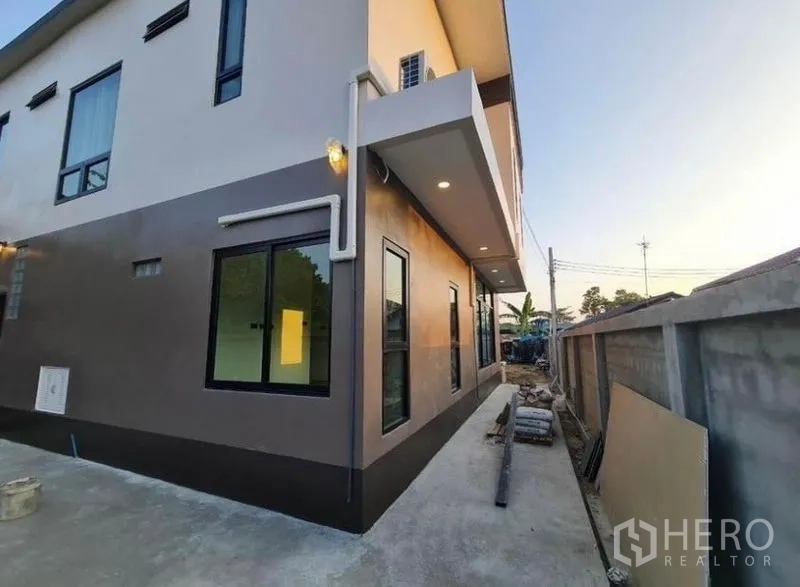 Detached House for sale in Sai Mai, Bangkok - Side exterior walkway of the home with windows and boundary wall.