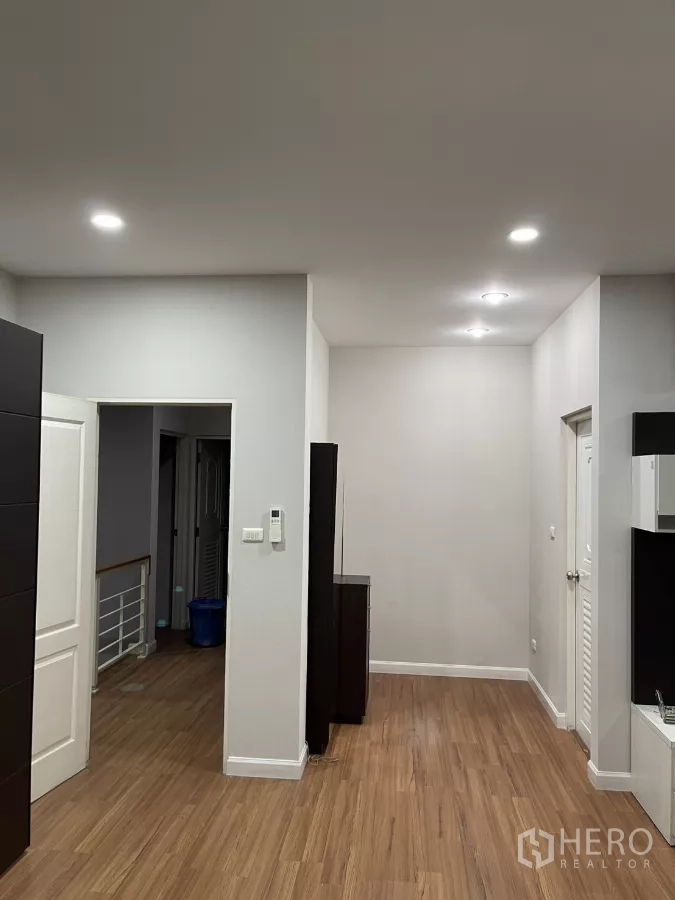 Detached House for rent in Bang Kapi, Bangkok - Second bedroom with white wardrobes, mirrored doors and open shelving.