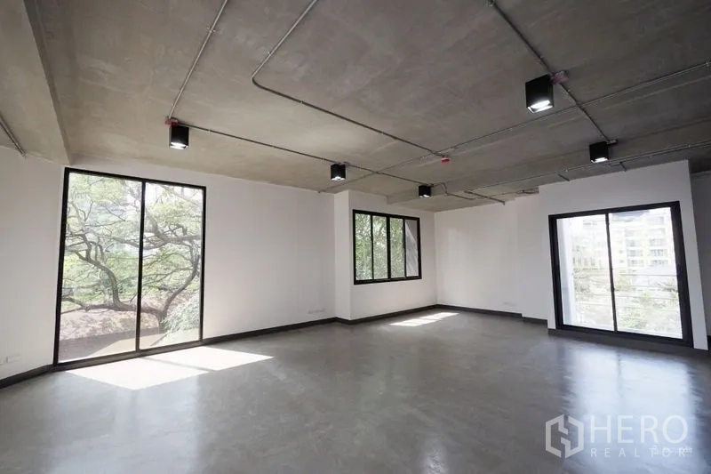 สำนักงาน ให้เช่าในWatthana, Bangkok - พื้นที่สำนักงานเปิดโล่ง พื้นปูนขัดมัน ฝ้าเปลือย พร้อมหน้าต่างบานใหญ่เห็นวิวต้นไม้