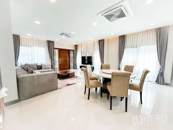 บ้าน ให้เช่าในBang Phli, Samut Prakan - พื้นที่รับประทานอาหารสว่าง โต๊ะกลม 6 ที่นั่ง เชื่อมต่อสู่ห้องนั่งเล่นกว้างพร้อมหน้าต่างบานใหญ่