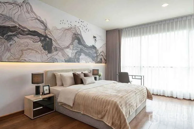 Condominium for rent in Pathum Wan, Bangkok - King-size bedroom with wall-to-wall art mural, bedside tables, and balcony window.
