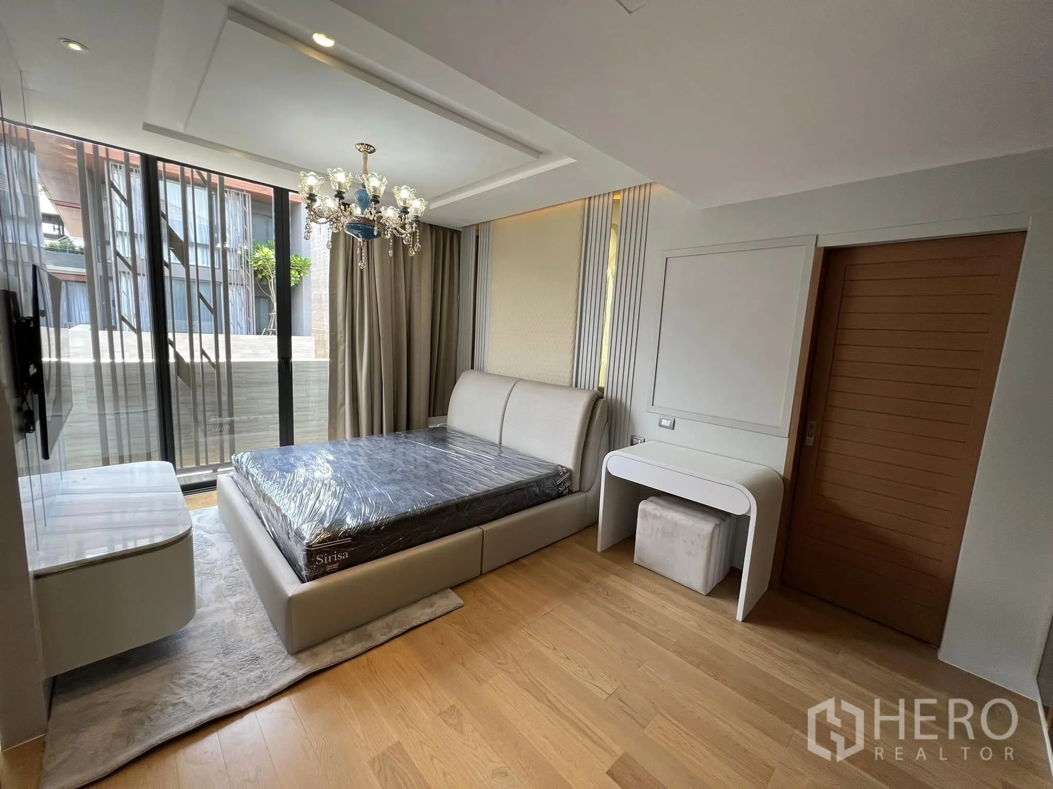 Detached House for rent or sale in Yan Nawa, Bangkok - Bedroom with chandelier, large windows and balcony access.