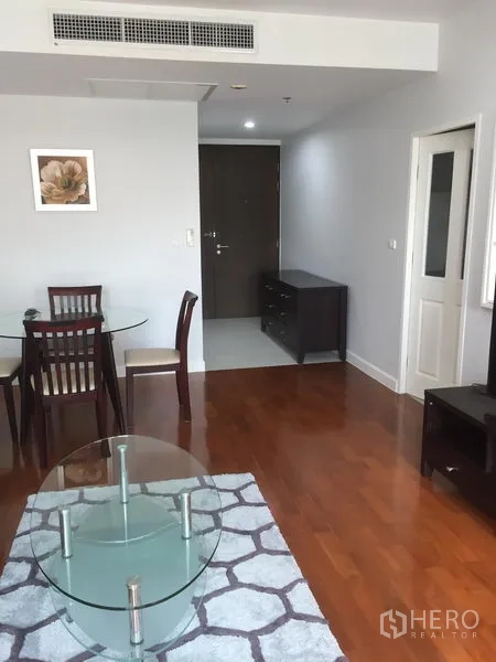Condominium for rent in Khlong Toei, Bangkok - Entrance hall leading to dining area with ceiling air vent, wooden door and console cabinet.