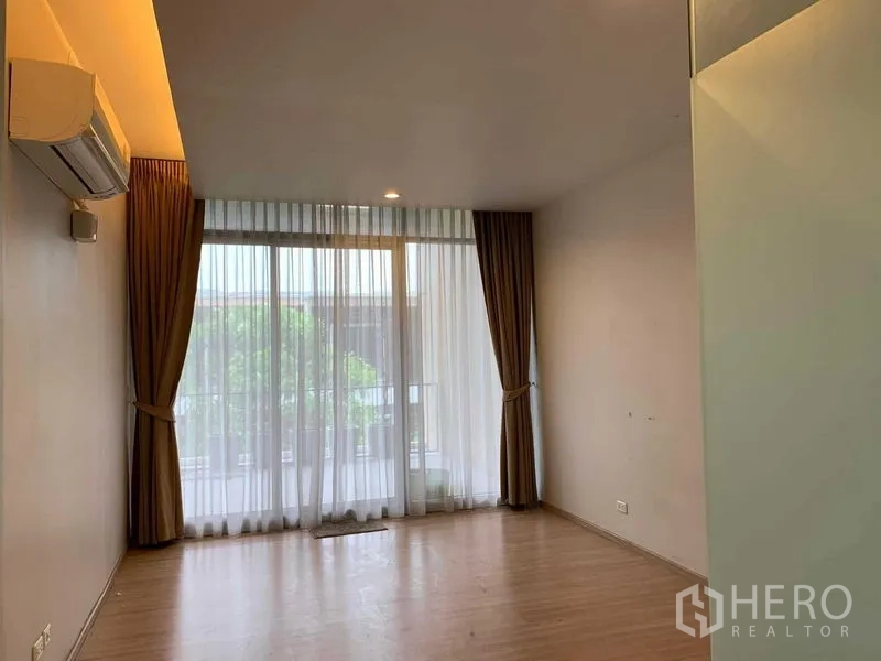 ทาวน์เฮาส์ ให้เช่าในKhan Na Yao, Bangkok - ห้องนอนพื้นไม้ มีแอร์ ประตูกระจกเต็มบานออกสู่ระเบียงและม่านทึบโปร่ง