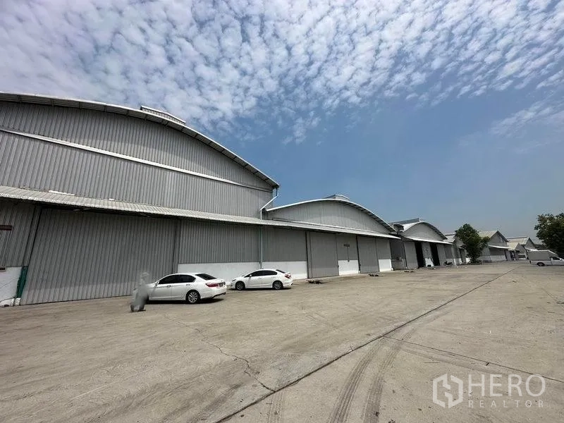 Warehouse for rent in Bang Pa-in, Phra Nakhon Si Ayutthaya - Row of connected warehouses with a wide concrete driveway and ample parking.