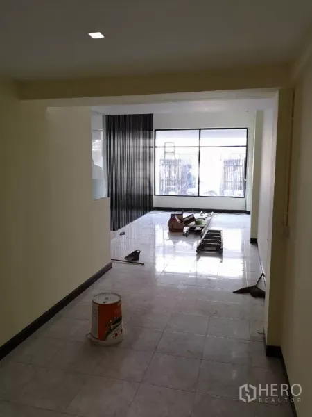 Home Office for rent in Yan Nawa, Bangkok - Open-plan ground floor with glossy tiles, full-height front window and slatted feature wall under renovation.