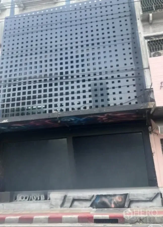 店屋 出租在Watthana, Bangkok - 临街店屋立面，黑色镂空金属屏与关闭的卷闸门。