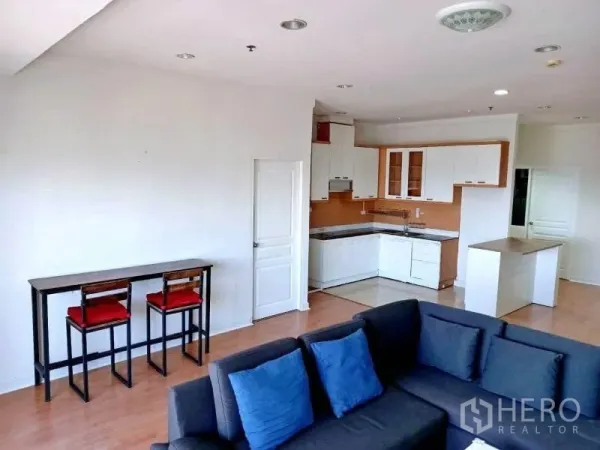 Condominium for rent in Khlong Toei, Bangkok - Living room connected to a breakfast bar and L-shaped kitchen in the corner.