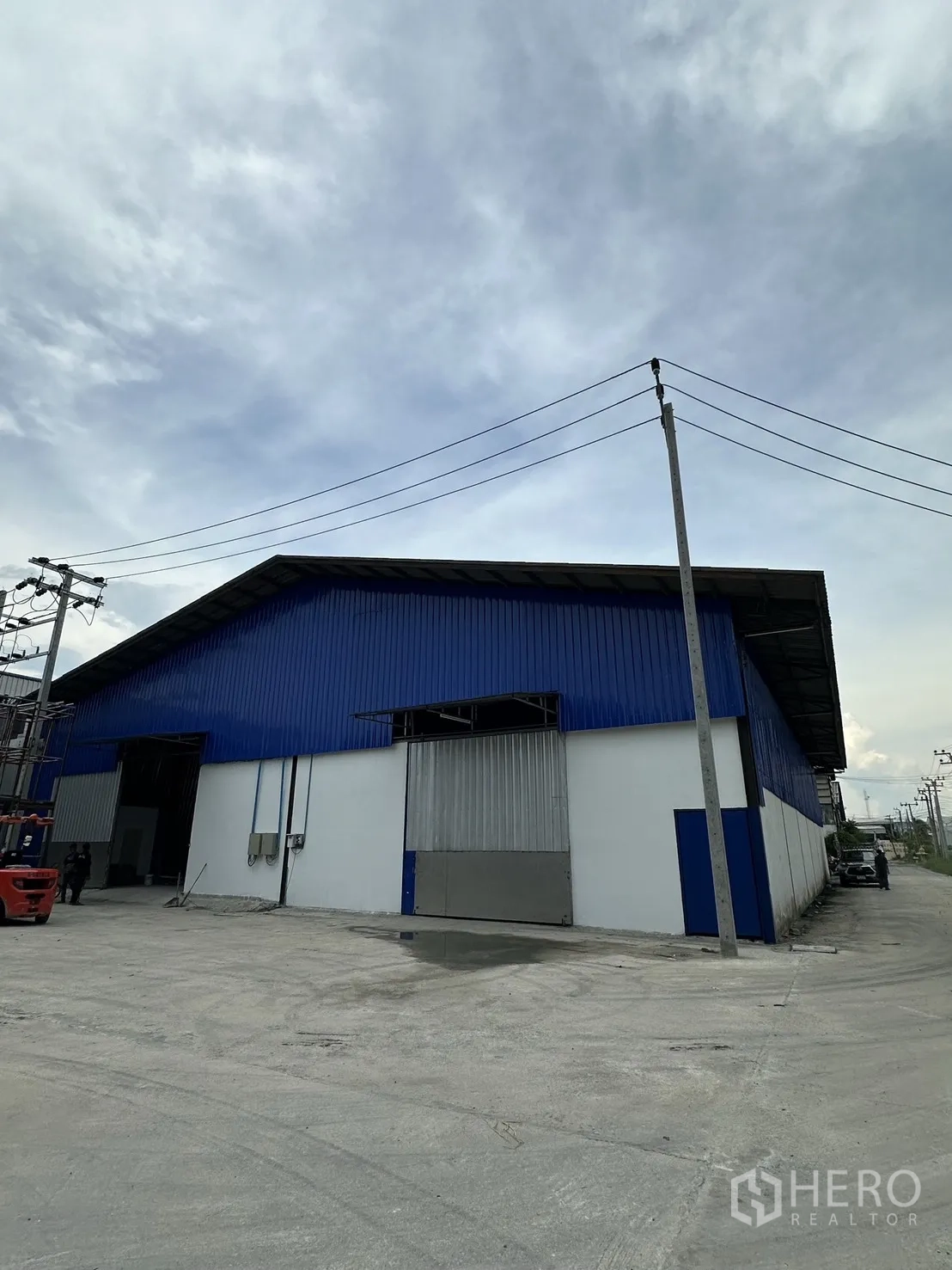 Warehouse for rent in Mueang Samut Prakan, Samut Prakan - Industrial warehouse exterior with large sliding door and wide concrete yard.