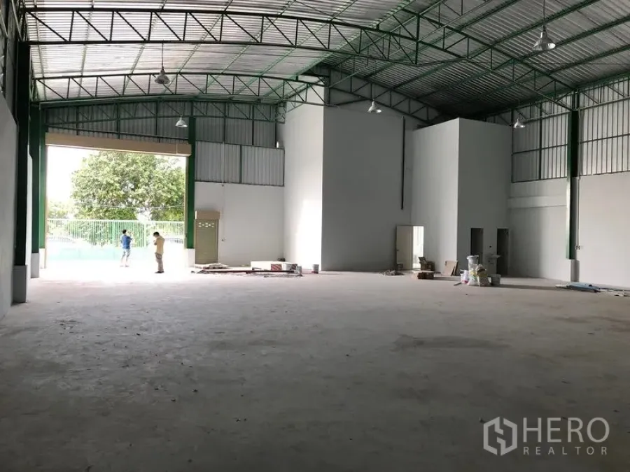 Factory for rent in Khlong Luang, Pathum Thani - Spacious factory hall with high steel-truss roof, wide loading door and smooth concrete floor.