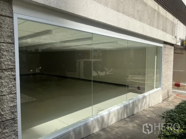 Retail Space for rent in Watthana, Bangkok - Street-level retail storefront with a wide floor-to-ceiling glass window and tiled walkway.