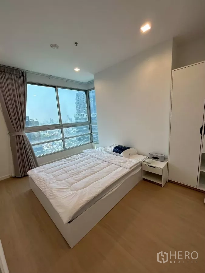 公寓 出租在Bang Rak, Bangkok - 主卧另一角度，含衣柜、床头柜与全景落地窗。